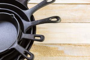 Cast iron skillets on a wood table.