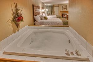 Jacuzzi tub filled with bubbles and two queen beds with fireplace at Pigeon Forge hotel