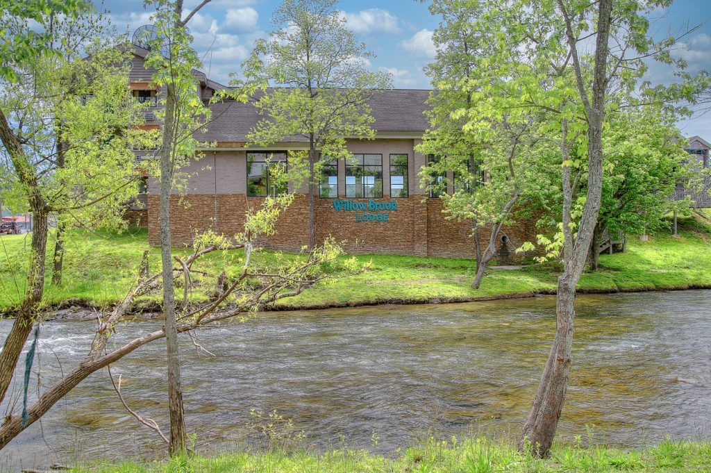 View of Willow Brook Lodge by the river in Pigeon Forge