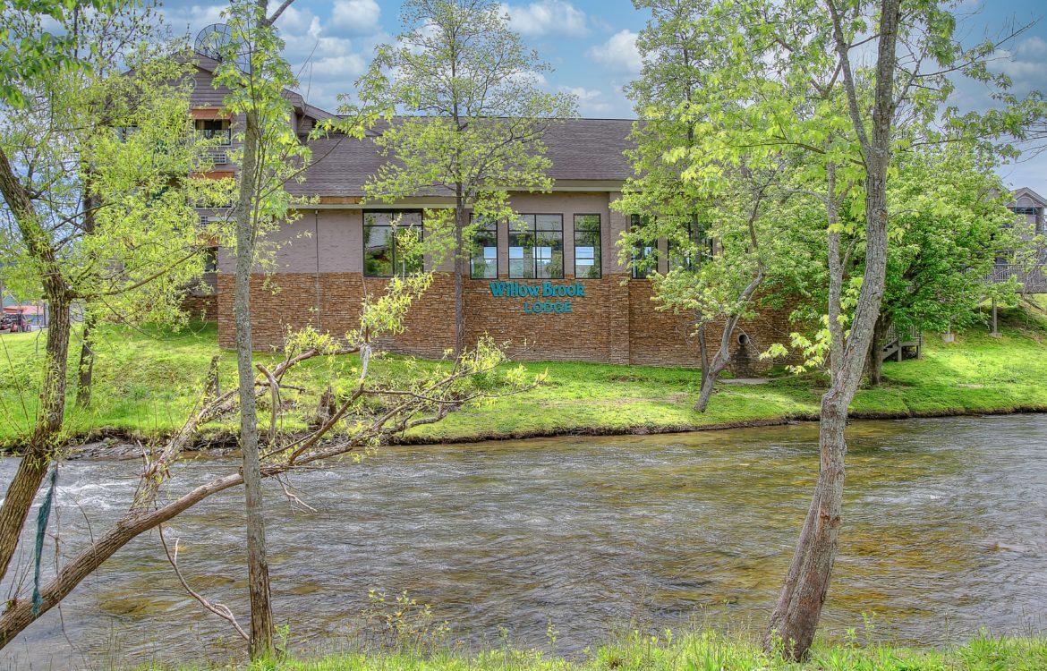View of Willow Brook Lodge by the river in Pigeon Forge