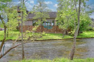 View of Willow Brook Lodge by the river in Pigeon Forge